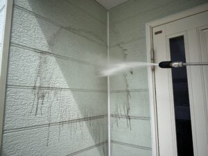 高圧洗浄で外壁の汚れを落とす様子