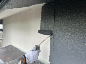 外壁をローラーで塗装している様子