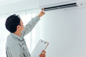 設置後のエアコンの試運転をする作業員